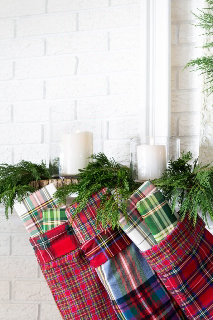 plaid Christmas stockings hanging from a mantel.