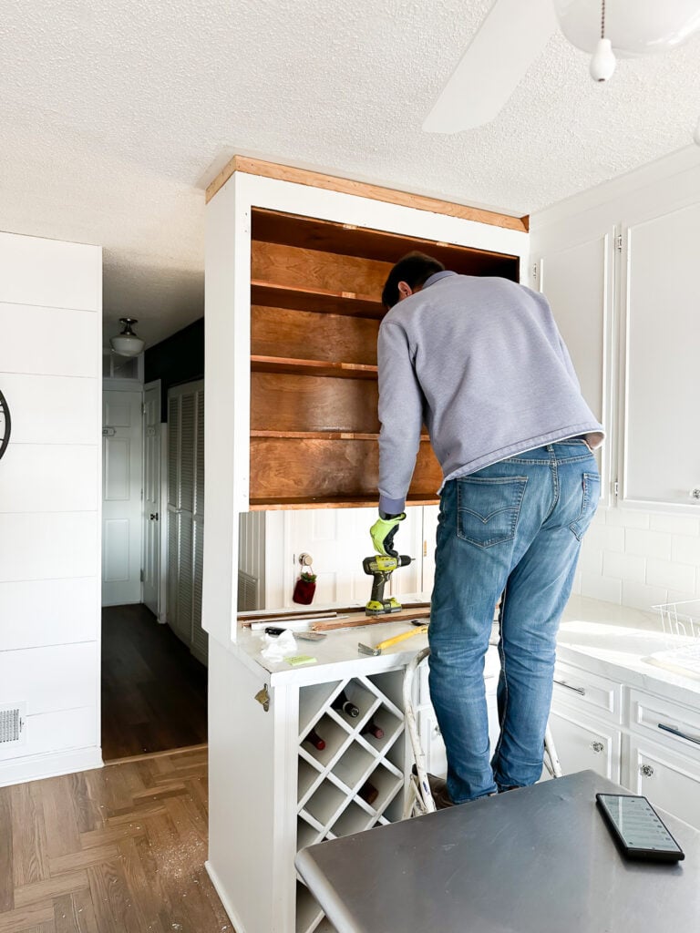 Showing how to remove a group of kitchen cabinets that are attached to wall and ceiling