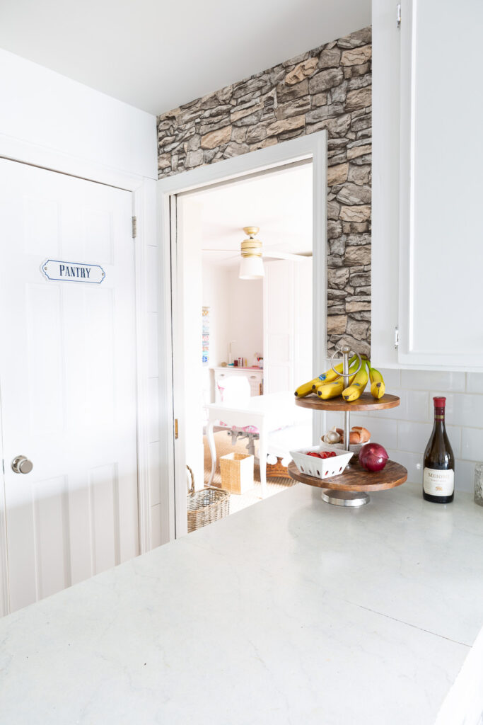 Faux stone wallpaper on accent wall in kitchen.