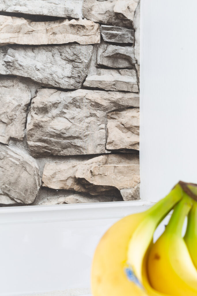 close up of faux stone wallpaper on accent wall in kitchen.