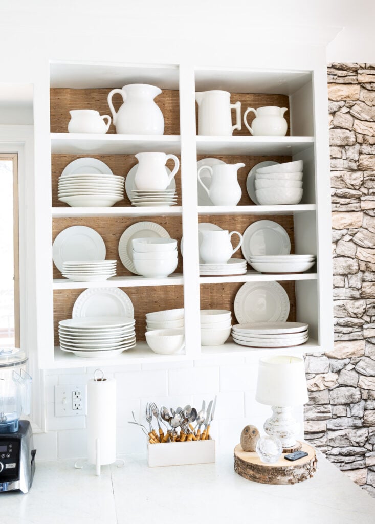 Open shelves in kitchen with wallpaper added to the back of each shelf to add contrast and interest.