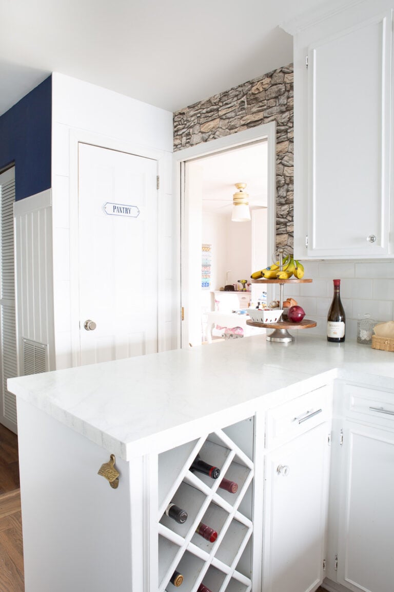 Looking at accent wall covered in faux stone wallpaper and a pocket door.