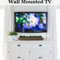 sideboard placed under a wall mounted TV . Text says - How to hide the cords on a wall mounted TV