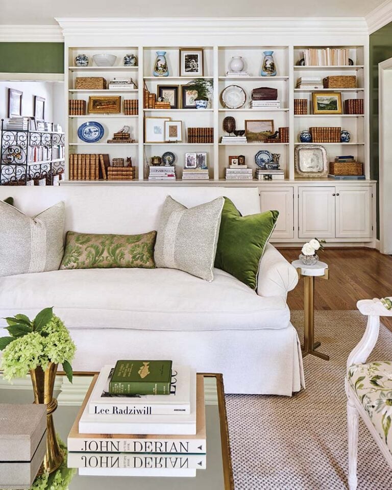 white sofa in a green and white room with bookshelves lining a wall.