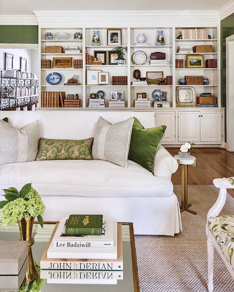 white sofa in a green and white room with bookshelves lining a wall.