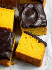 Squares of vegan Brazilian carrot cake on a sheet of baking paper.