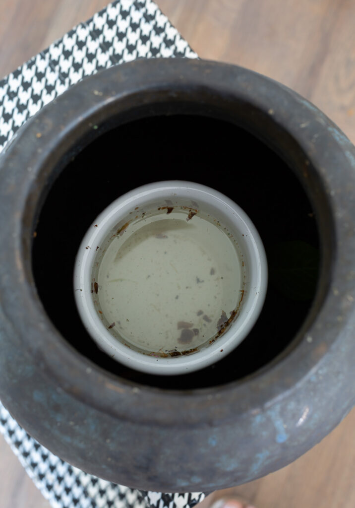 looking down into a small urn in a planter to hold water for fresh flowers
