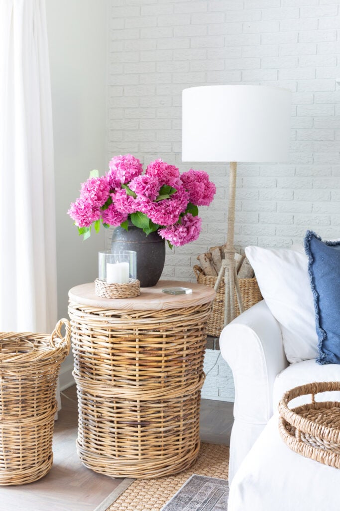 white and blue living room with pink hydrangeas in a black planter