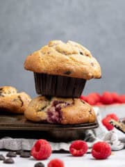 A stack of two vegan choc chip raspberry muffins in a muffin pan.