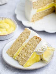 A slice of vegan lemon layer cake on a white plate.
