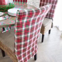 Looking at the back of one of the classic holiday plaid fabric covered dining chairs around a dining table.
