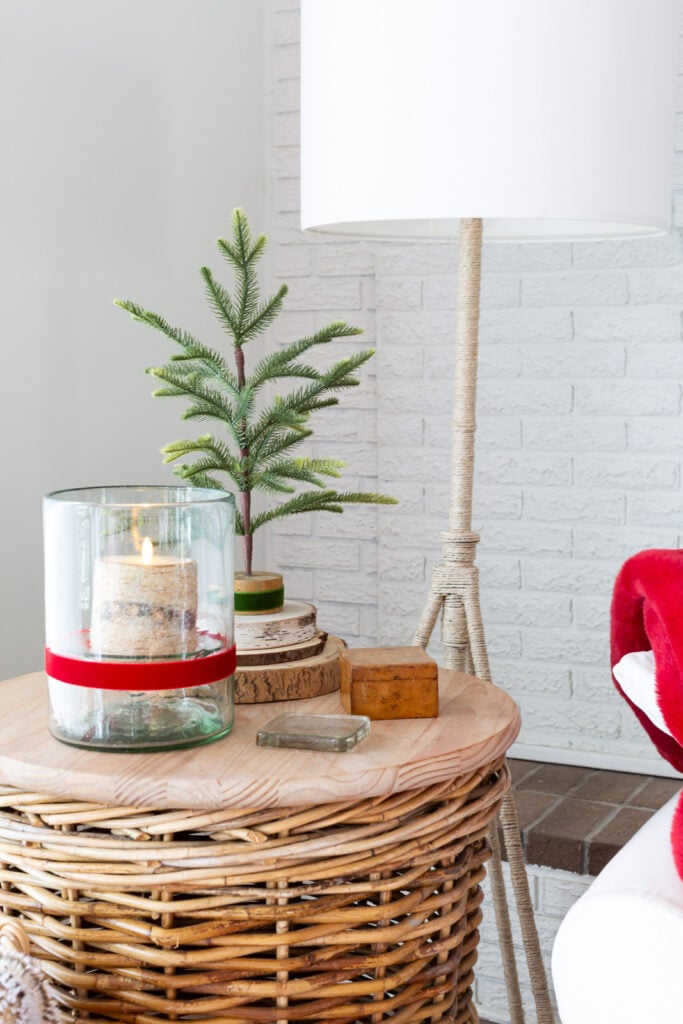 a round wicker basket side table decorated in a simple way for Christmas.