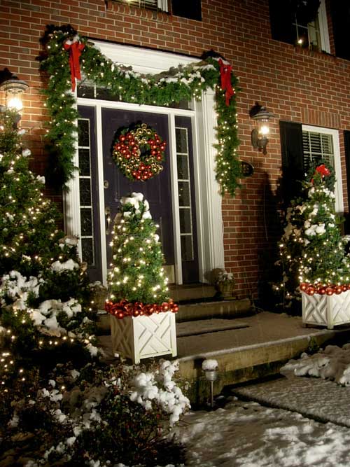 Snow-covered home decorated with Christmas decorations and garland